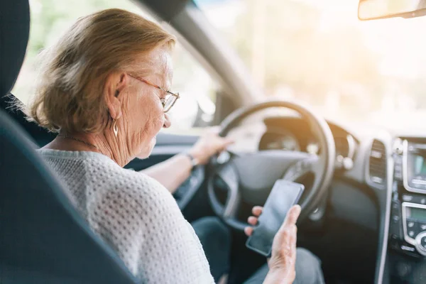 Starsza Kobieta Kierownicą Samochodu Pomocą Jej Telefon — Zdjęcie stockowe