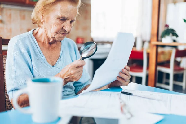 老妇人看她的公用事业账单和文书工作 — 图库照片