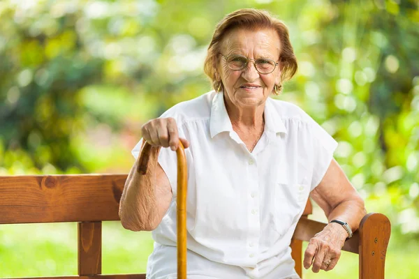 Ältere Frau Sitzt Auf Einer Bank Park Und Entspannt — Stockfoto