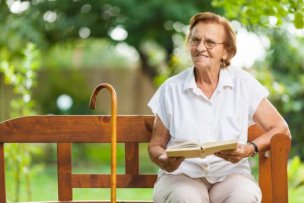 在公园户外长凳上坐和放松的老年妇女 — 图库照片