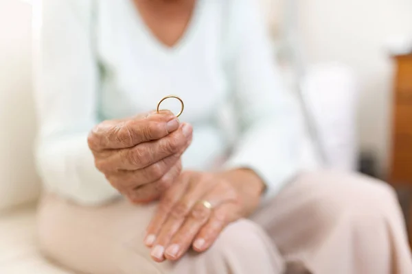 伤心欲绝的老年妇女抱着他丈夫结婚戒指 — 图库照片