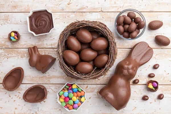 Ciocolată Iepuraș de Paști, ouă și dulciuri pe fundal rustic — Fotografie, imagine de stoc