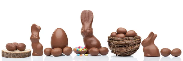 Chocolate Easter bunny, eggs and sweets on white background — Stock Photo, Image