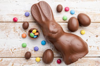 Çikolata Paskalya bunny, yumurta ve tatlılar rustik arka plan üzerinde