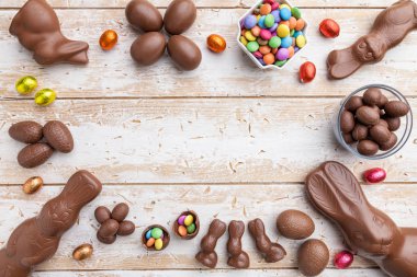 Çikolata Paskalya bunny, yumurta ve tatlılar rustik arka plan üzerinde