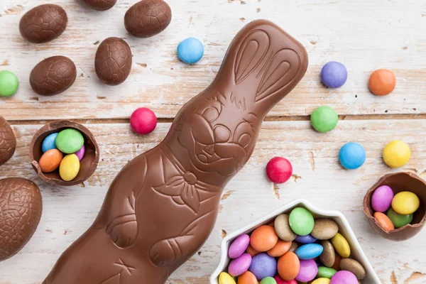 Choklad Easter bunny, ägg och godis på rustika bakgrund — Stockfoto