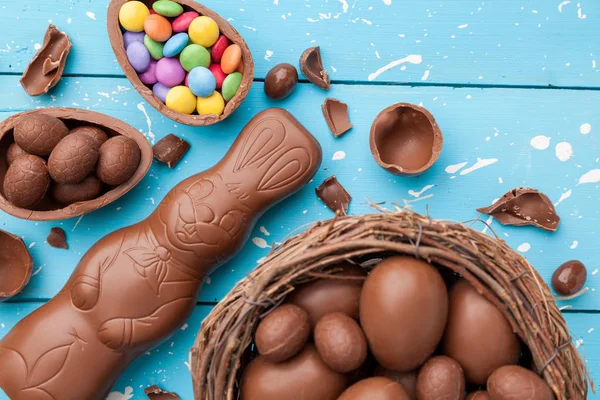 Ciocolată Iepuraș de Paști, ouă și dulciuri pe fundal rustic — Fotografie, imagine de stoc