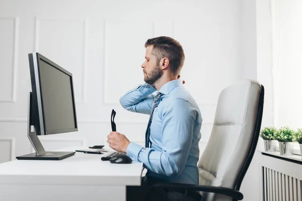 Pracownik biurowy z bólem siedząc na biurku przez cały dzień — Zdjęcie stockowe
