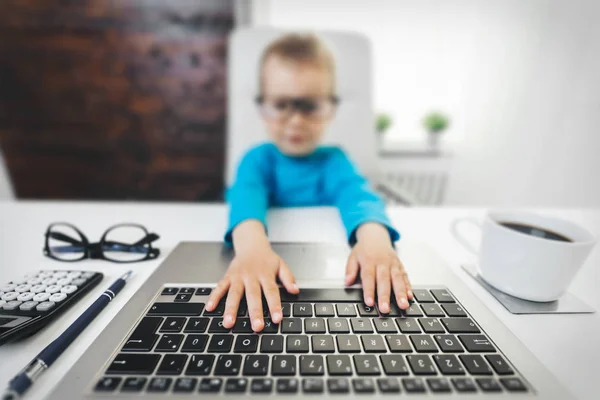 Criança bonito com óculos usando um laptop — Fotografia de Stock