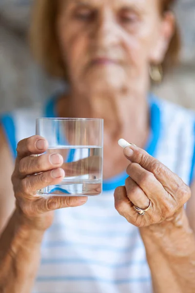 Senior kvinna tar hennes dagliga medicinering — Stockfoto