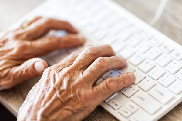 Starsza kobieta wpisując na klawiaturze — Zdjęcie stockowe