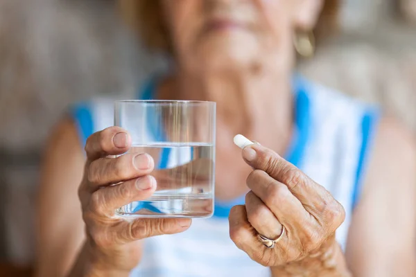 Senior kvinna tar hennes dagliga medicinering — Stockfoto