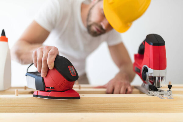 Мужской плотник работает над проектом в своей мастерской