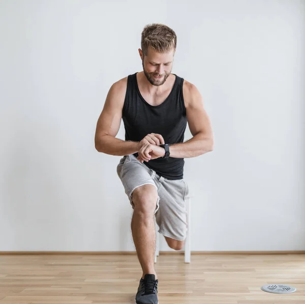 Joven Guapo Haciendo Ejercicio Casa Con Reloj Inteligente —  Fotos de Stock