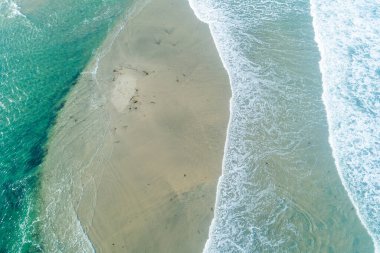 Dalgaların soyut doğal arkaplanı kumun üzerinde süzülüyor, soyut doğa