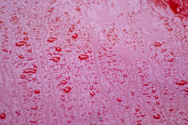 Soyut bir makro yağmur damlası resmi pembe boyalı bir yüzey üzerinde Soyut Arkaplan Güzelliği