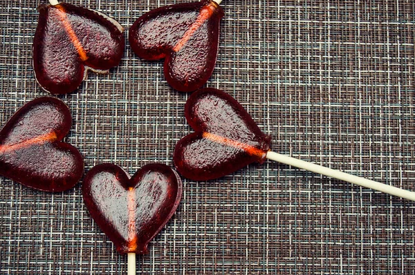 kahverengi bir arka planda kalpler şeklinde lolipop