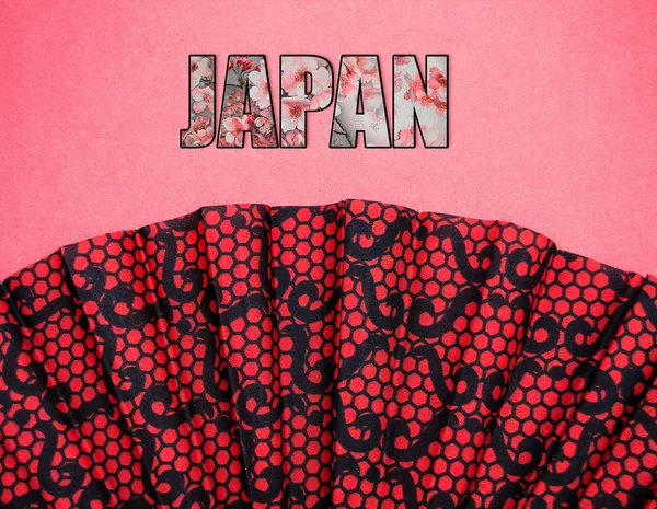 yazıt Japonya ile pembe bir arka plan üzerinde kırmızı desenli fan