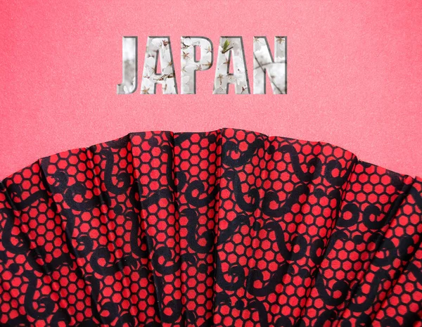 yazıt Japonya ile pembe bir arka plan üzerinde kırmızı desenli fan