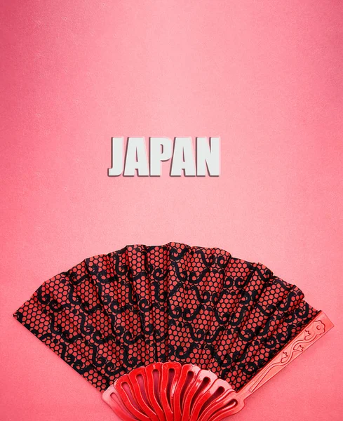 yazıt Japonya ile pembe bir arka plan üzerinde kırmızı desenli fan