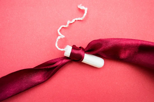 pembe arka plan üzerinde kırmızı kurdele ile bağlı kadın tampon