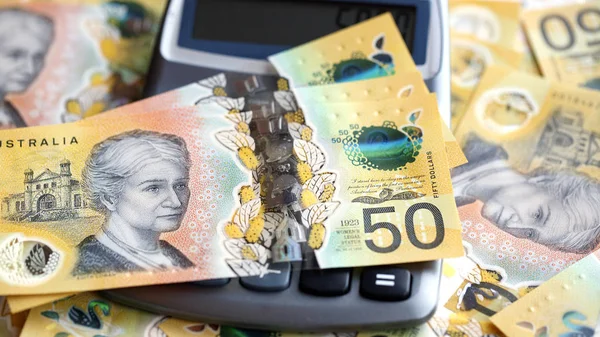 電卓を通るオーストラリアの50ドル紙幣 新しい2019年発行法案は偽造を阻止するように設計されており ノートは透明なホログラフィックストリップでポリマーと耐水性です — ストック写真
