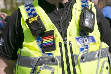 Polis Memuru toplumda çeşitliliği desteklemek ve iyi ilişkileri teşvik gay Pride Parade bir Gökkuşağı Bayrağı sembolü giyiyor.