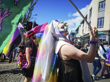 Swansea, İngiltere: 04 Mayıs 2019: Gay Pride Parade katılımcıları ve destekçileri. Bir çapraz giyinme adam canlı bir kıyafet giyiyor, peruk ve makyaj o bir Gay Pride Parade yürür gibi - toplumda çeşitlilik ve alternatif yaşam tarzları desteklemek için.