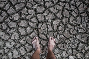 Toprak kuraklık alan stand yürüyerek çatlamak.