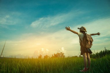 Kız yeşil bir alanda ayakta, kızlar taze hava kucaklamak.