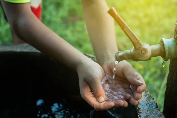 Barn använda hand ramen vatten att dricka, vatten brist koncept. — Stockfoto