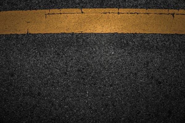 Línea amarilla vieja sobre textura negra de asfalto . — Foto de Stock