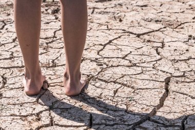 Kuraklık nedeniyle zemin de yürüyen ayaklar.