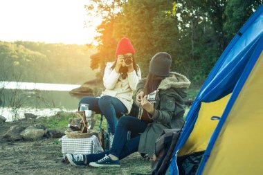 Turistler kadın ve arkadaşlar tatilde nehir üzerinde kamp.