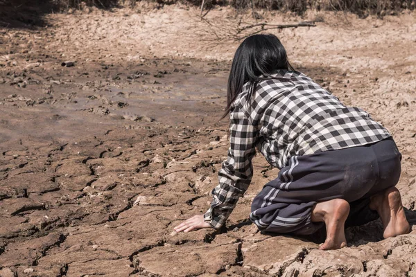 Kadın umutsuzlukla çorak bir zeminde oturdu.. — Stok fotoğraf