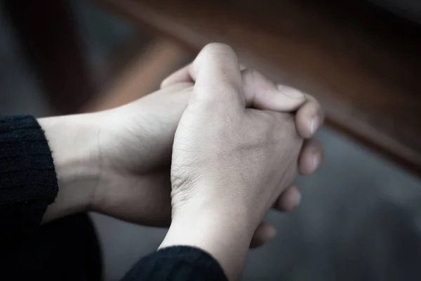 기도를 드리는 손을 잡고 있는 한 여성의 손. — 스톡 사진