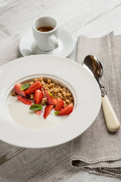 新鮮なイチゴと緑のミントとオートミールのクローズ アップ写真はコーヒーのカップの灰色の木製テーブルの上葉白い皿にミルクで — ストック写真
