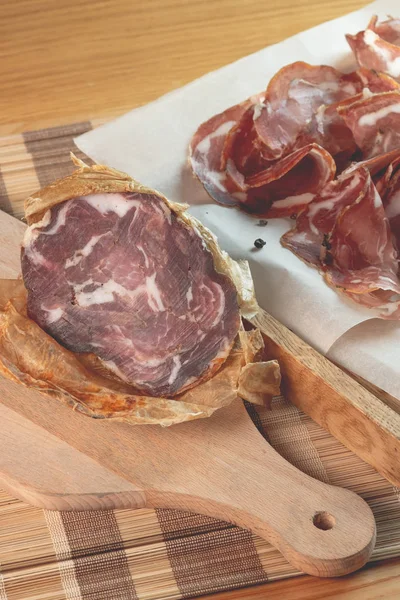 Sliced ham on wooden board. Fresh prosciutto. Pork ham sliced.