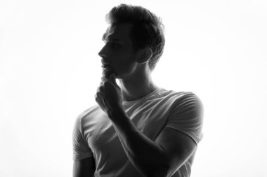 düşünceli delikanlı onun çene ayakta beyaz arka plan üzerinde dokunmadan