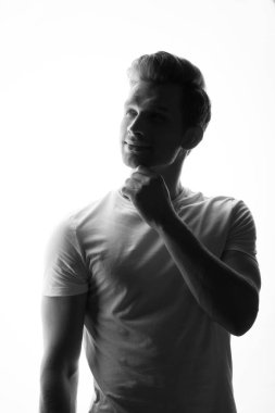 düşünceli delikanlı onun çene ayakta beyaz arka plan üzerinde dokunmadan