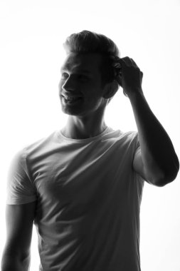 Beyaz arka plan üzerinde duran genç düşünceli adam