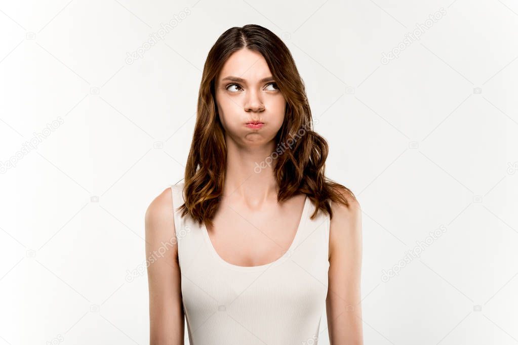 portrait of young woman with sad facial expression standing on white background