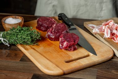 Zanaat sığır eti biftek mermer eti fileto mignon pastırma içinde yemek pişirmek için seçili. Ahşap arka plan.