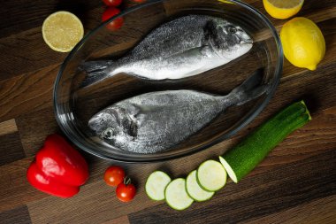 Taze deniz balık narenciye ve sebze malzemelerle ahşap masa