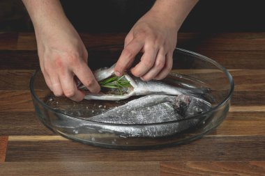 Şef deniz ile baharat ahşap masa üzerinde balık pişirme