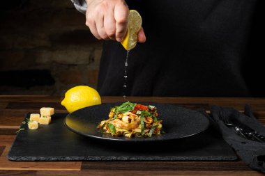 Şef yemek peynir ve domates sosu, siyah arka plan mutfak merdivenlerinde ile kabak İtalyan yemek pişirme.