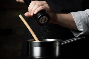 Siyah arka plan kopya metin tarifi mutfak göreve adımları Şef ellerimden metal tencerede pişirme domates sosu.