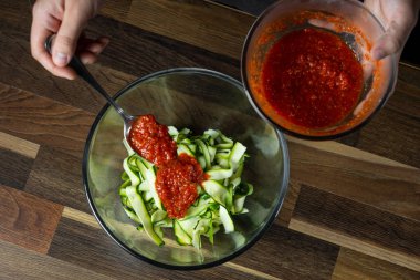 Şef yemek peynir ve domates sosu, siyah arka plan mutfak merdivenlerinde ile kabak İtalyan yemek pişirme.