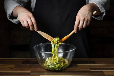 Şef yemek peynir ve domates sosu, siyah arka plan mutfak merdivenlerinde ile kabak İtalyan yemek pişirme.