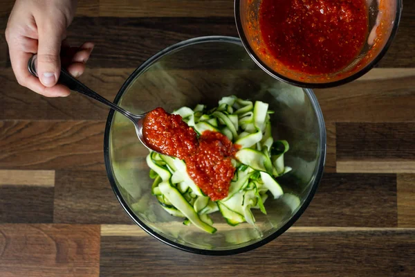 Şef yemek peynir ve domates sosu, siyah arka plan mutfak merdivenlerinde ile kabak İtalyan yemek pişirme.